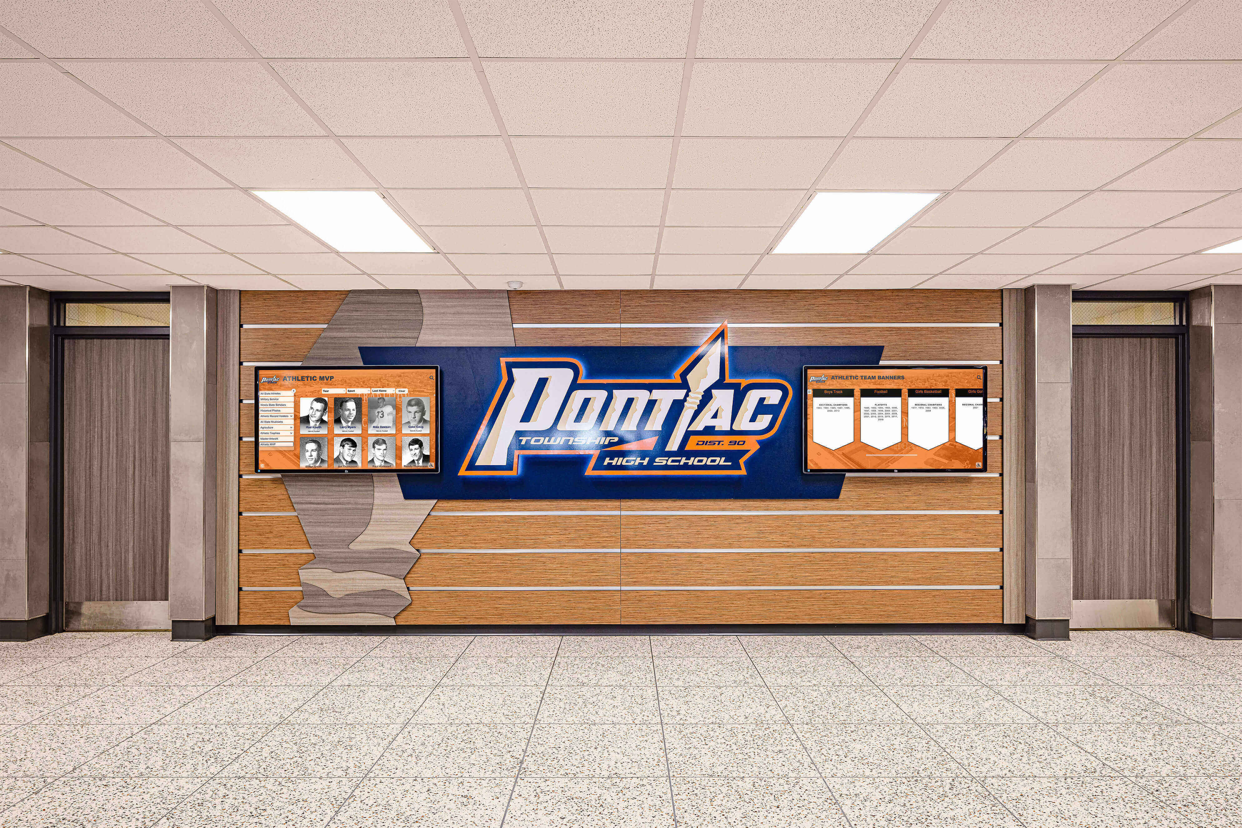 Athletic honor boards and school identity display in a high school hallway — the recognition commitments that drive booster club spending need the same documentation discipline as the reimbursement policy that governs that spending Pontiac High School hallway with athletic honor boards and school logo display